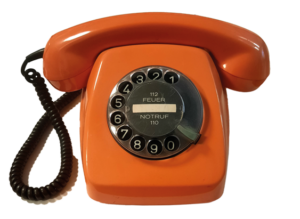 Ein orangenes Wählscheibentelefon